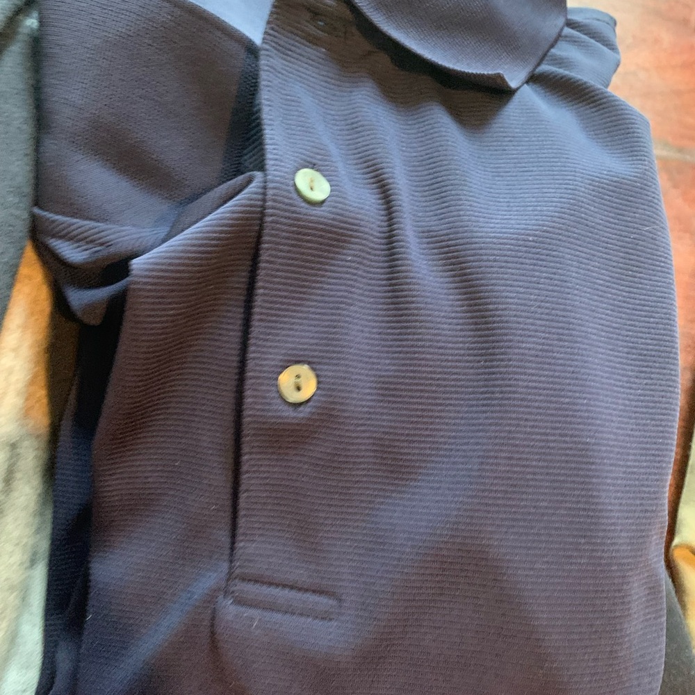 Blue work shirt manufactured by Ben Hogan’s. Side 2XL. 30% recycled polyester.